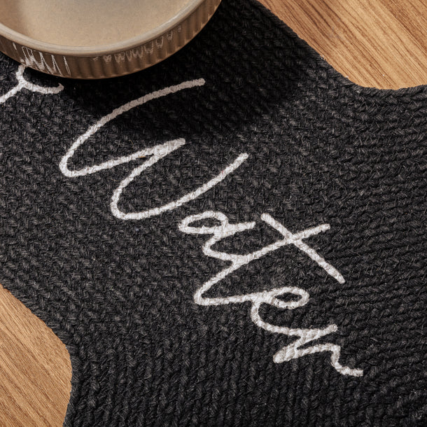 Close-up of black Benedict Pet Placemat – organic cotton bone-shaped feeding mat with ‘Food’ and ‘Water’ text