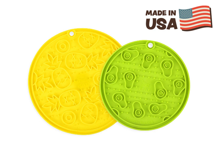 Green and yellow ZoomieRex EverLick Mats by Pet P.L.A.Y. side by side with Made in USA stamp
